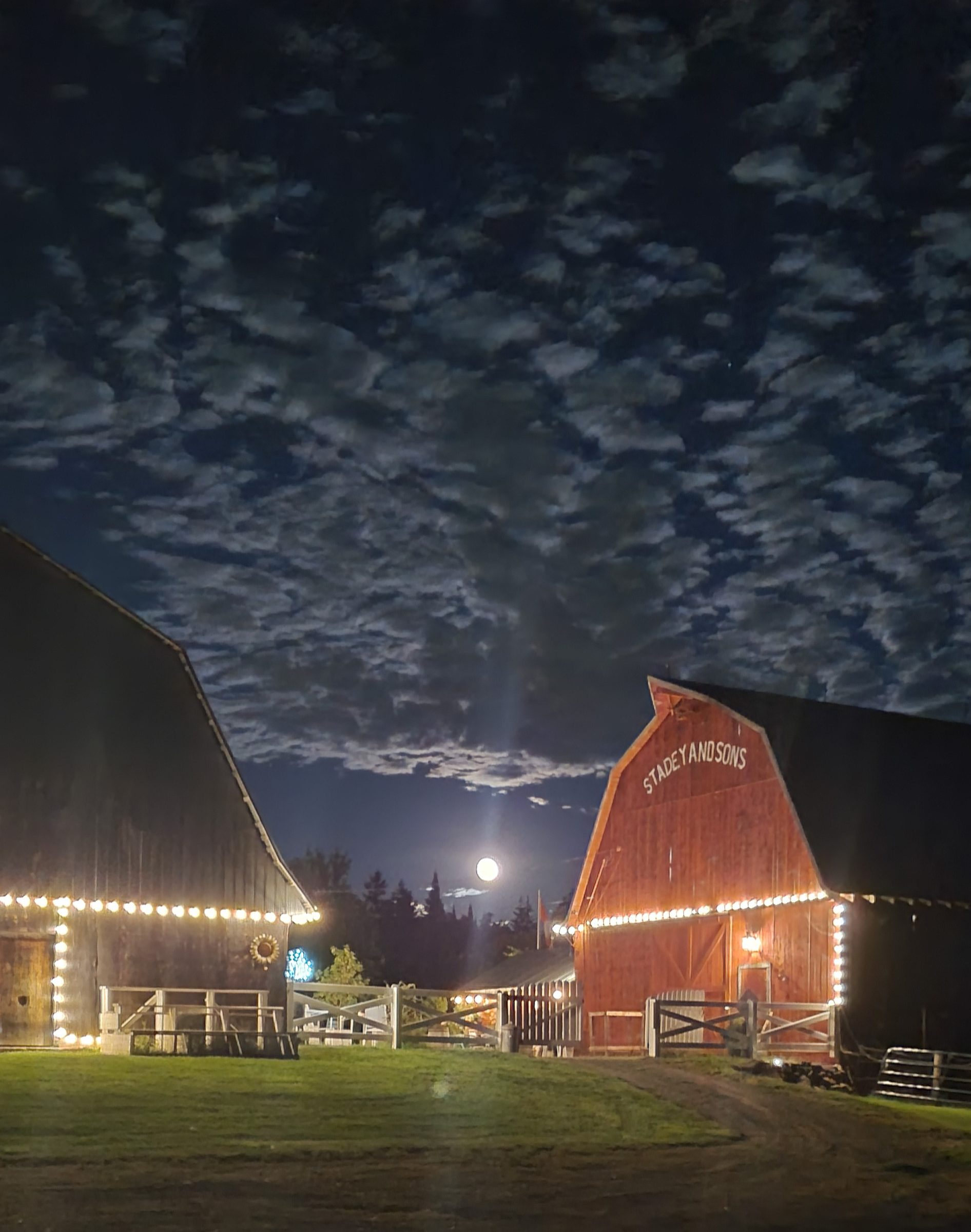 The barns illuminated at night under a moonlit sky