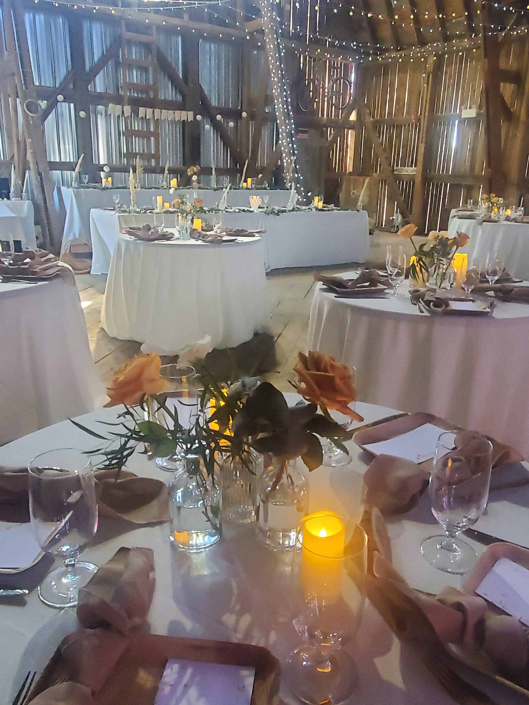 Candlelit table settings with string lights overhead