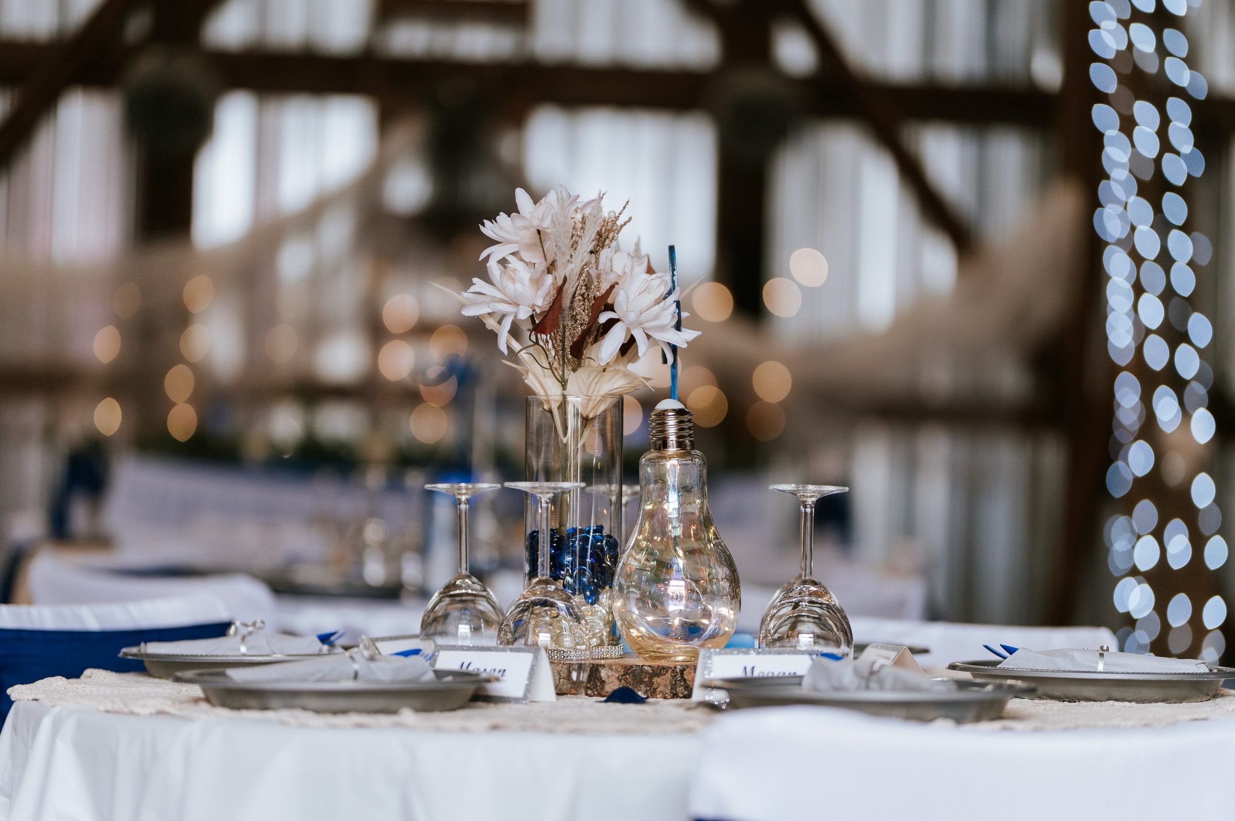Table centerpiece with dried flowers and crystal glassware, fairy light bokeh